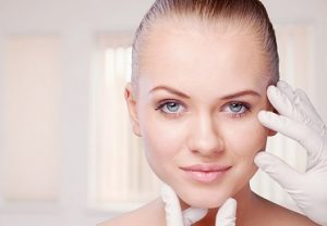 Beautician touching attractive health woman face. Plastic surgery.
